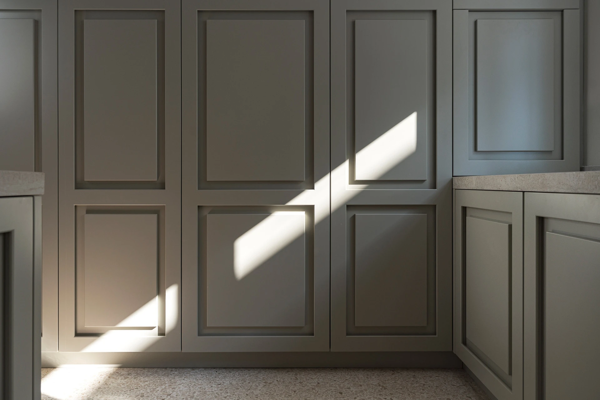 Cucina artigianale: pannellature a telaio della dispensa illuminate dalla luce naturale